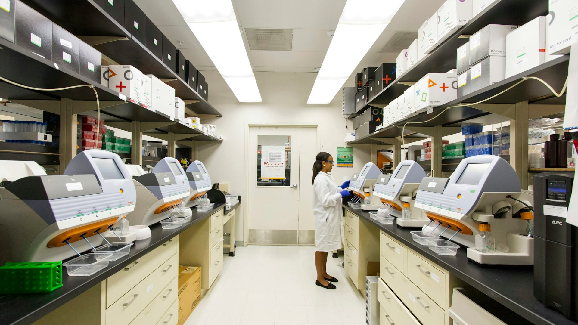 Medical laboratory scientist analyzing clinical specimen tests with a microscope for AIMS skills assessment