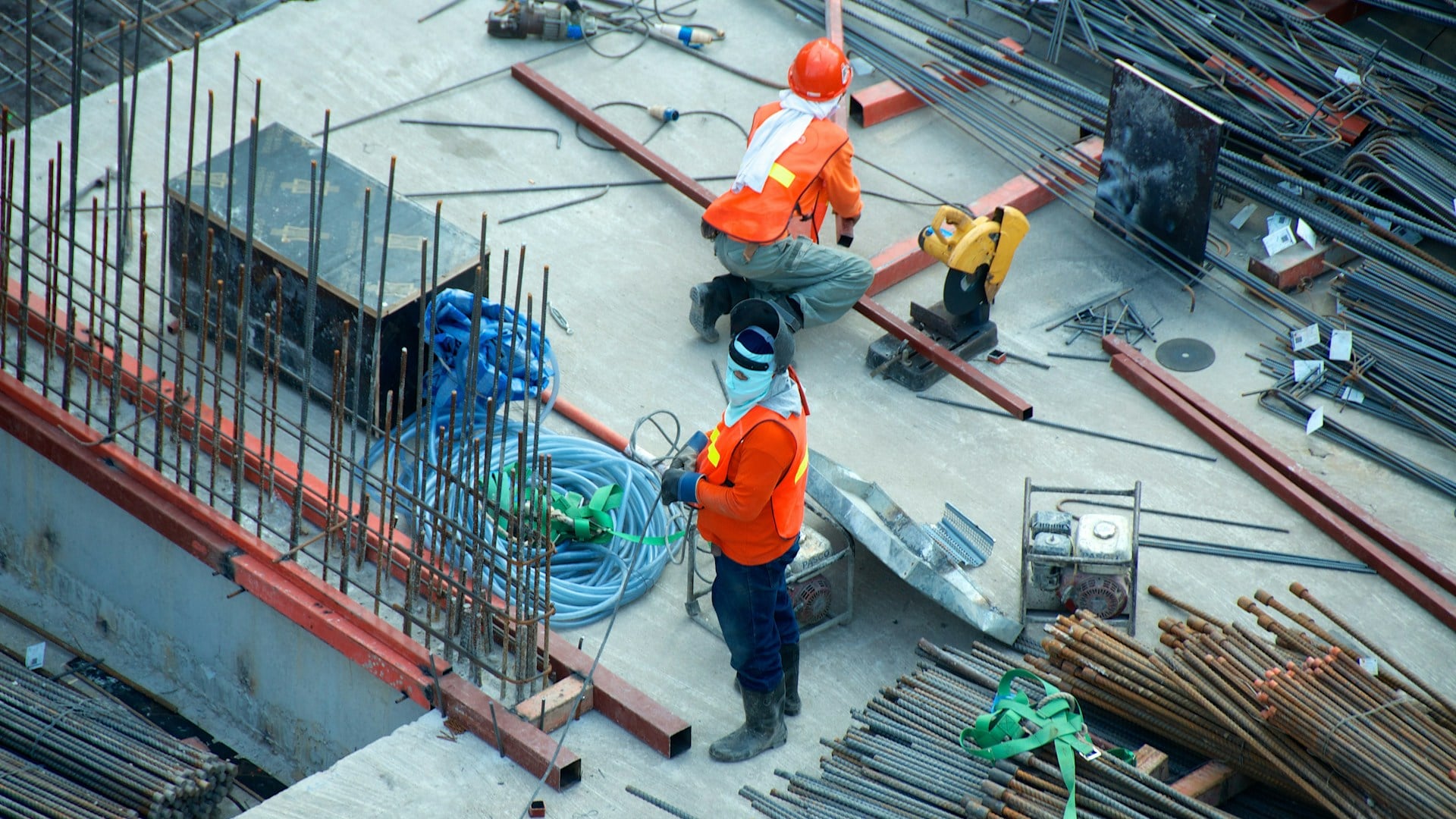 Quantity surveyor on a commercial construction site verifying structural bills of quantities for AIQS skills assessment